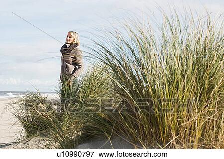 Woman standing on beach View Large Photo Image Stock Photo - Woman standing on beach. Fotosearch