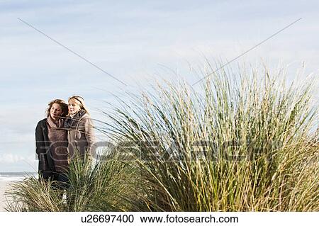 Woman standing together on beach View Large Photo Image Stock Image - Woman standing together on beach. Fotosearch