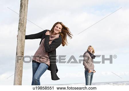 Woman swinging from pole on beach View Large Photo Image Stock Image - Woman swinging from pole on beach. Fotosearch