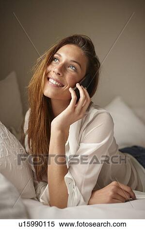 Woman talking on cell phone in bed View Large Photo Image Stock Photography - Woman talking on cell phone in bed. Fotosearch
