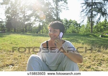Woman talking on cell phone outdoors View Large Photo Image Stock Image - Woman talking on cell phone outdoors. Fotosearch