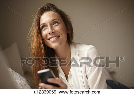 Woman using cell phone in bed View Large Photo Image Stock Photo - Woman using cell phone in bed. Fotosearch