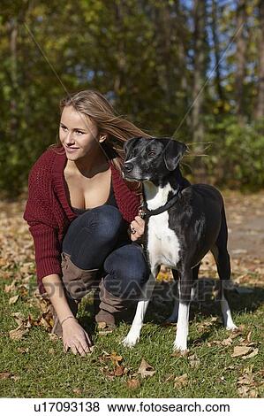 Woman walking dog in autumn leaves View Large Photo Image Stock Photo - Woman walking dog in autumn leaves. Fotosearch