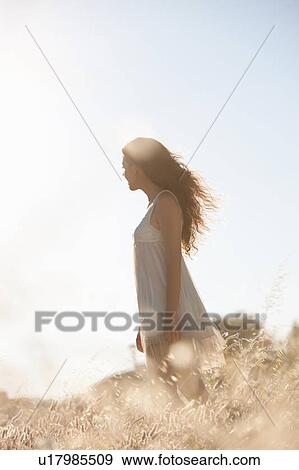 Stock Photo - Woman walking in tall grass. Fotosearch