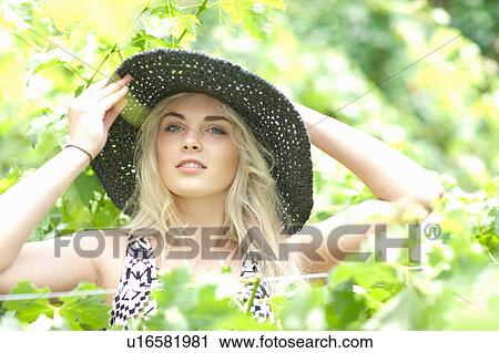 Woman wearing sun hat in tall plants View Large Photo Image Stock Image - Woman wearing sun hat in tall plants. Fotosearch