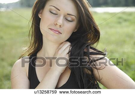 Woman with eyes closed in field View Large Photo Image Stock Photo - Woman with eyes closed in field. Fotosearch
