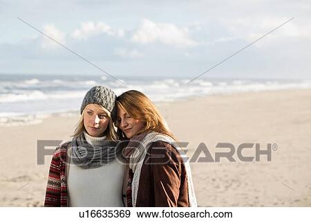 Stock Photo - Women hugging on beach. Fotosearch