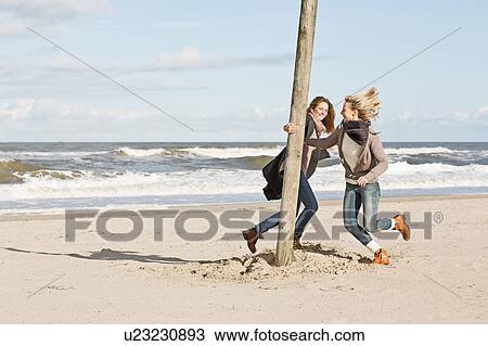 Stock Image - Women playing on beach. Fotosearch