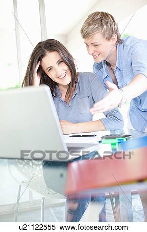 Women working together at desk View Large Photo Image Stock Photography - Women working together at desk. Fotosearch