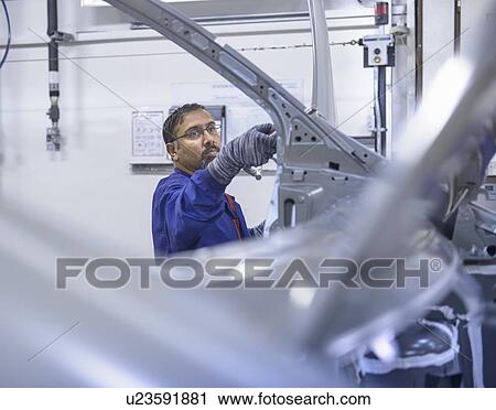 Worker applying sealant in car factory View Large Photo Image Stock Image - Worker applying sealant in car factory. Fotosearch