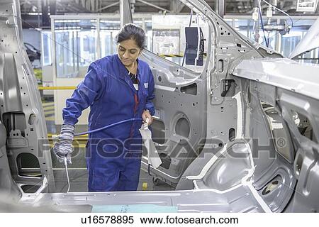 Worker applying sealant in car factory View Large Photo Image Stock Photography - Worker applying sealant in car factory. Fotosearch