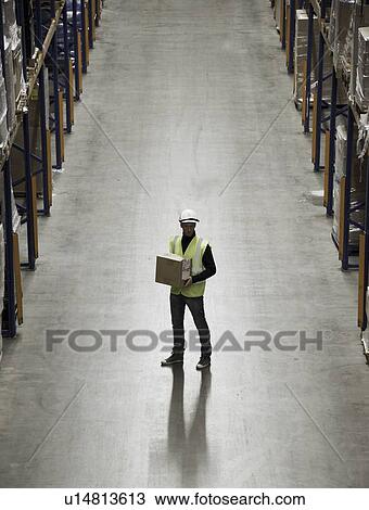 Worker carrying box in warehouse View Large Photo Image Stock Image - Worker carrying box in warehouse. Fotosearch