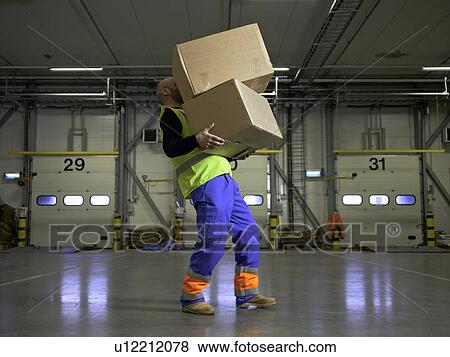 Stock Photo - Worker carrying boxes in warehouse. Fotosearch