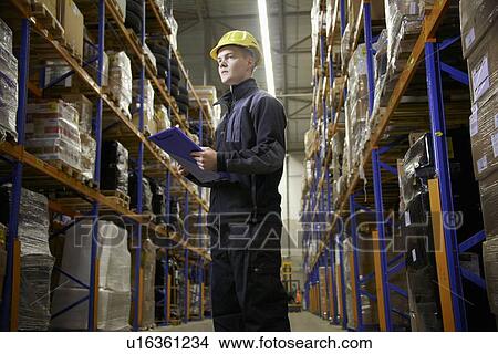 Worker checking stock in warehouse View Large Photo Image Picture - Worker checking stock in warehouse. Fotosearch