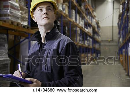 Worker checking stock in warehouse View Large Photo Image Stock Image - Worker checking stock in warehouse. Fotosearch