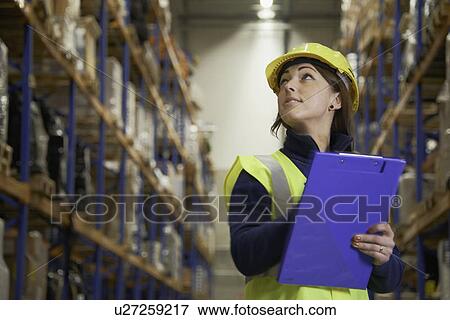 Worker checking stock in warehouse View Large Photo Image Stock Photo - Worker checking stock in warehouse. Fotosearch