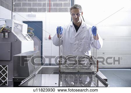 Stock Image - Worker cleaning with ultrasonics. Fotosearch
