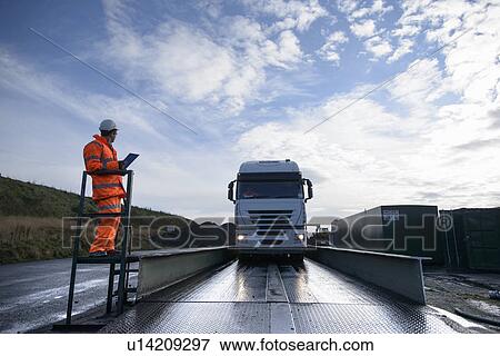 Worker directing truck on scales View Large Photo Image Stock Photo - Worker directing truck on scales. Fotosearch