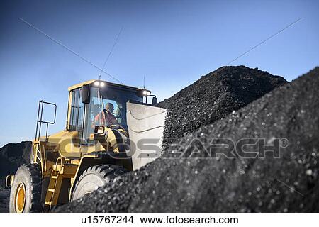 Picture - Worker driving excavator at coal mine. Fotosearch