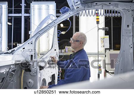 Worker inspecting car in factory View Large Photo Image Stock Image - Worker inspecting car in factory. Fotosearch