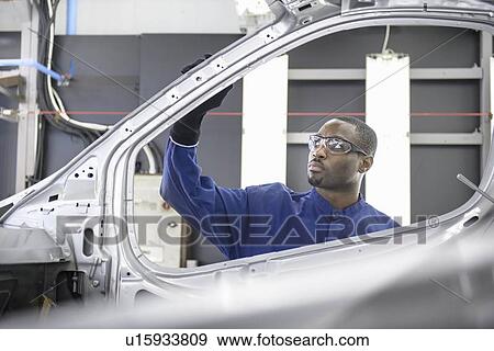 Worker inspecting car in factory View Large Photo Image Stock Photo - Worker inspecting car in factory. Fotosearch