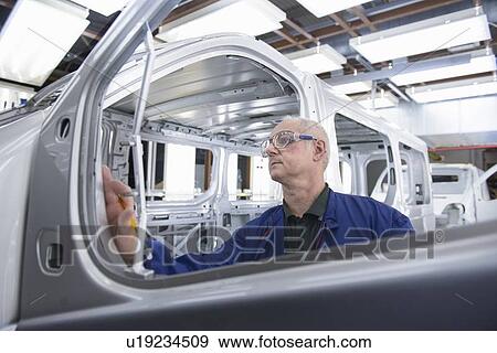 Worker inspecting car in factory View Large Photo Image Stock Photo - Worker inspecting car in factory. Fotosearch