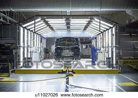 Stock Photograph - Worker inspecting car in factory. Fotosearch