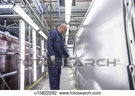 Worker inspecting vehicle in car factory View Large Photo Image Stock Image - Worker inspecting vehicle in car factory. Fotosearch