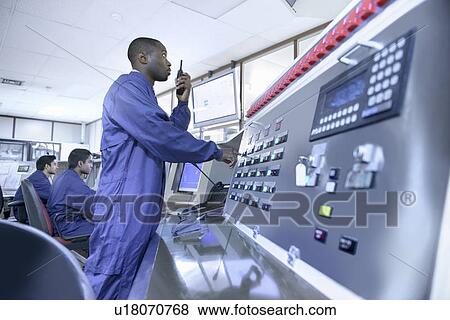 Stock Photo - Worker on walkie talkie in car factory. Fotosearch