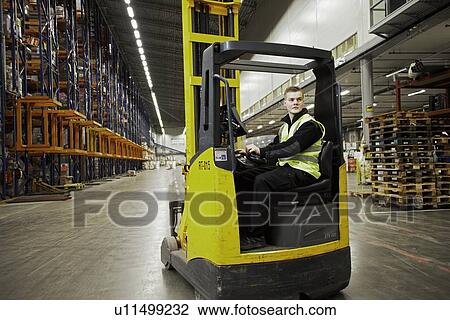 Worker operating forklift in warehouse View Large Photo Image Stock Image - Worker operating forklift in warehouse. Fotosearch