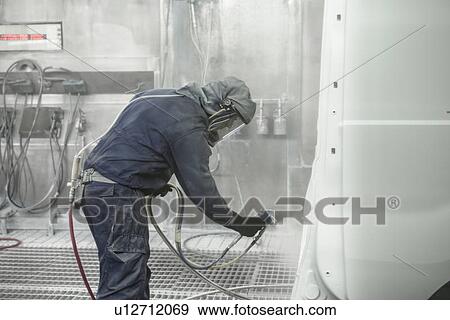 Worker spray painting in car factory View Large Photo Image Stock Photo - Worker spray painting in car factory. Fotosearch