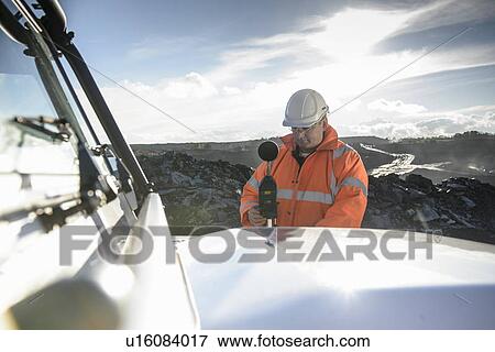 Stock Photo - Worker using noise equipment on truck. Fotosearch