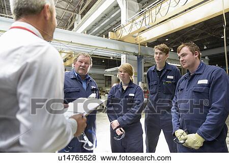 Stock Photo - Workers and businessman in factory. Fotosearch
