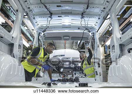 Workers fitting parts in car factory View Large Photo Image Stock Photograph - Workers fitting parts in car factory. Fotosearch