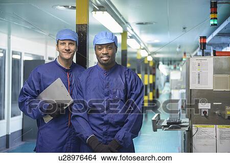 Workers standing in car factory View Large Photo Image Picture - Workers standing in car factory. Fotosearch