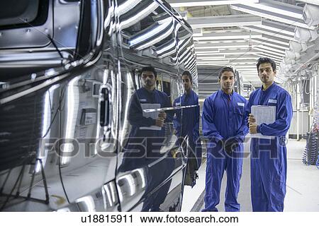 Workers standing in car factory View Large Photo Image Stock Image - Workers standing in car factory. Fotosearch