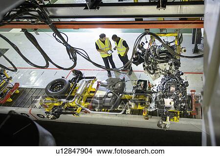 Picture - Workers talking in car factory. Fotosearch