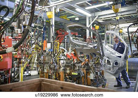 Stock Photograph - Workers welding doors in car factory. Fotosearch
