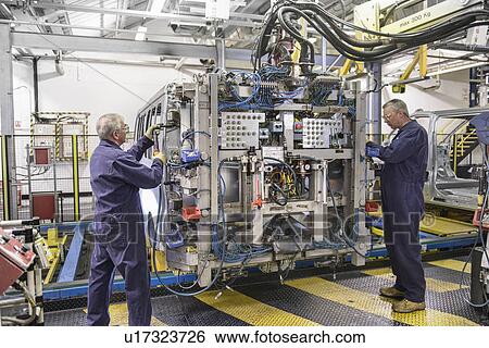 Workers with machinery in car factory View Large Photo Image Stock Photograph - Workers with machinery in car factory. Fotosearch