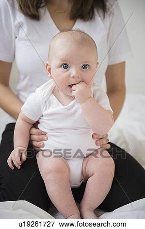 Stock Photo - baby boy (2-5 months) held by mother. Fotosearch