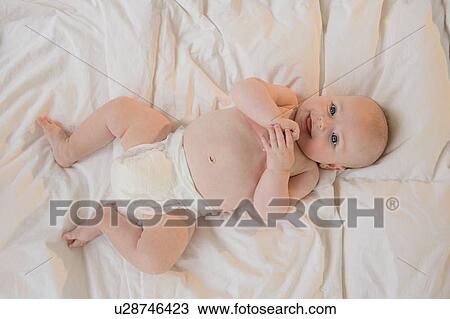 Baby boy (2-5 months) lying on back View Large Photo Image Stock Image - Baby boy (2-5 months) lying on back. Fotosearch
