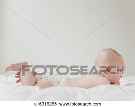 Stock Photography - Baby boy (2-5 months) lying on front. Fotosearch