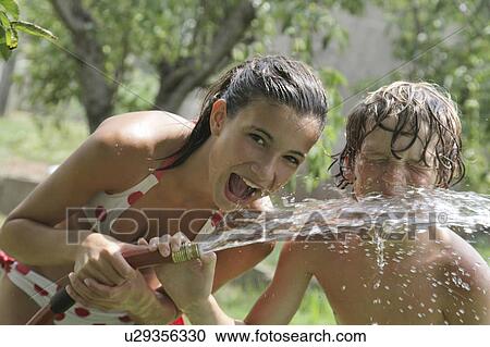 Boy (10-11) drinking from water hose in summer View Large Photo Image Stock Image - Boy (10-11) drinking from water hose in summer. Fotosearch