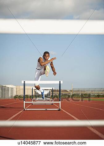 Boy (12-13) hurdling on running track View Large Photo Image Stock Photo - Boy (12-13) hurdling on running track. Fotosearch