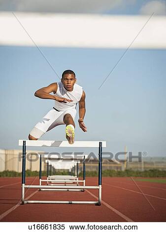 Boy (12-13) hurdling on running track View Large Photo Image Stock Photography - Boy (12-13) hurdling on running track. Fotosearch