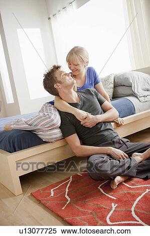 Cheerful couple embracing in bedroom View Large Photo Image Stock Photography - Cheerful couple embracing in bedroom. Fotosearch