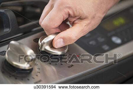 Close-up of hand adjusting stove burner View Large Photo Image Picture - Close-up of hand adjusting stove burner. Fotosearch