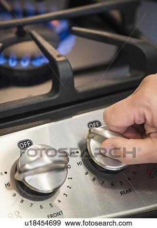 Close-up of hand adjusting stove burner View Large Photo Image Stock Photo - Close-up of hand adjusting stove burner. Fotosearch