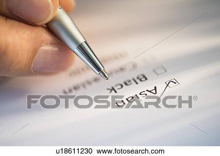 Stock Image - Close-up of hand filling out form. Fotosearch