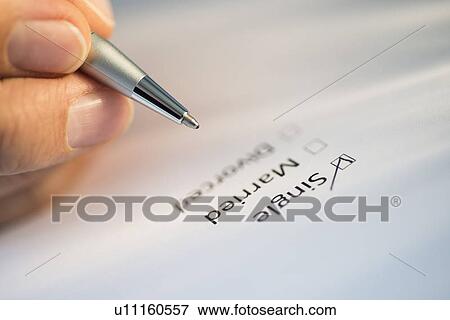 Stock Photo - Close-up of hand filling out form. Fotosearch